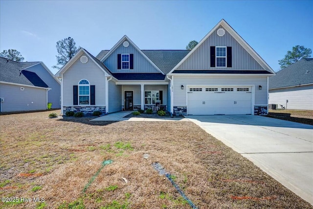 craftsman inspired home featuring a porch, concrete driveway, a front lawn, stone siding, and board and batten siding