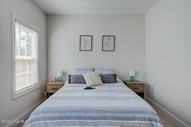 bedroom featuring multiple windows, carpet, and baseboards