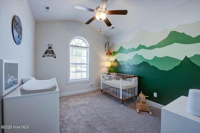 carpeted bedroom with baseboards, a crib, ceiling fan, and vaulted ceiling