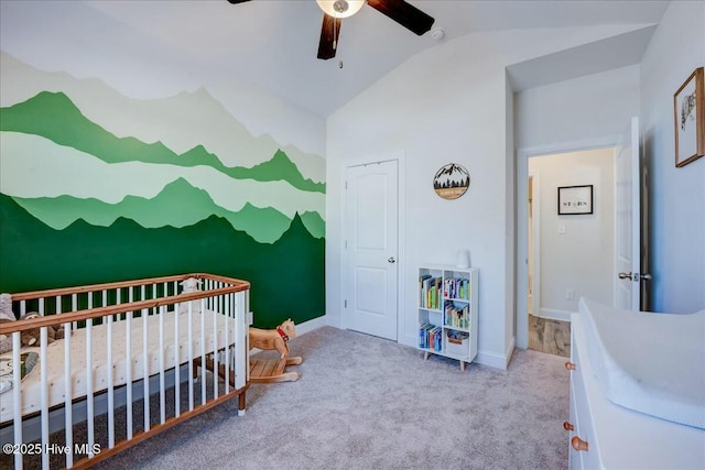 bedroom with baseboards, carpet, ceiling fan, lofted ceiling, and a nursery area