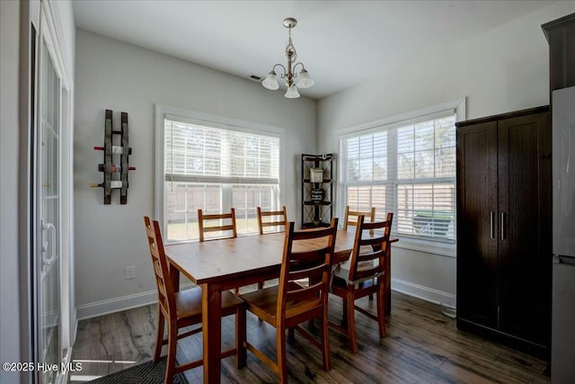 dining area with visible vents, baseboards, a chandelier, and dark wood-style flooring