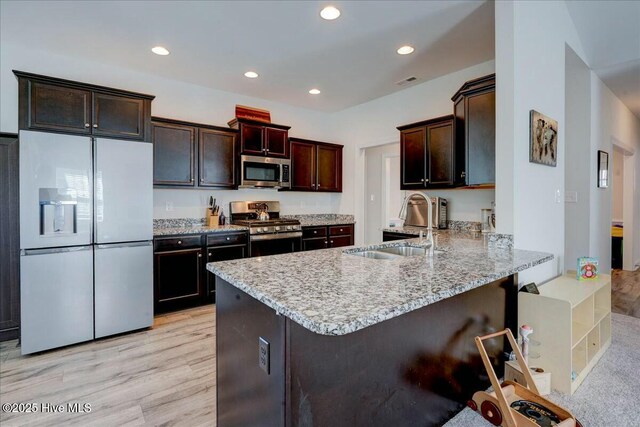 kitchen with recessed lighting, a peninsula, stainless steel appliances, and a sink