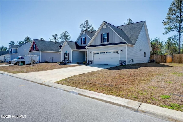 view of front of property with fence, concrete driveway, a front lawn, a garage, and board and batten siding