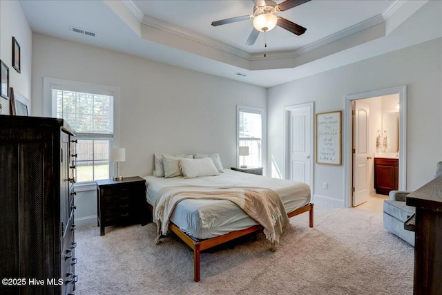 carpeted bedroom with a raised ceiling, baseboards, visible vents, and ornamental molding