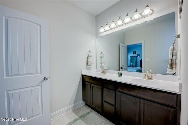 full bathroom featuring ensuite bath, double vanity, baseboards, and a sink