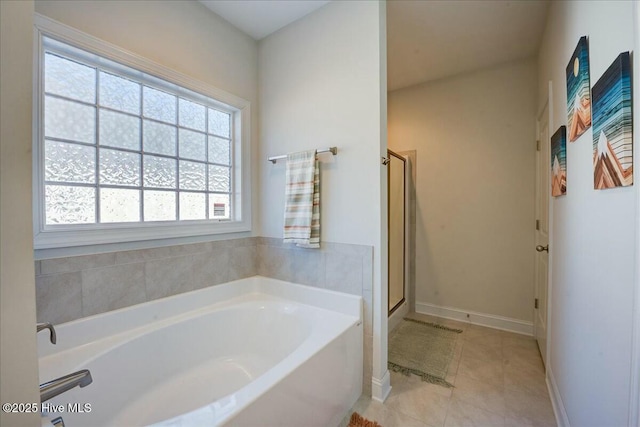 full bath featuring tile patterned floors, baseboards, a stall shower, and a bath