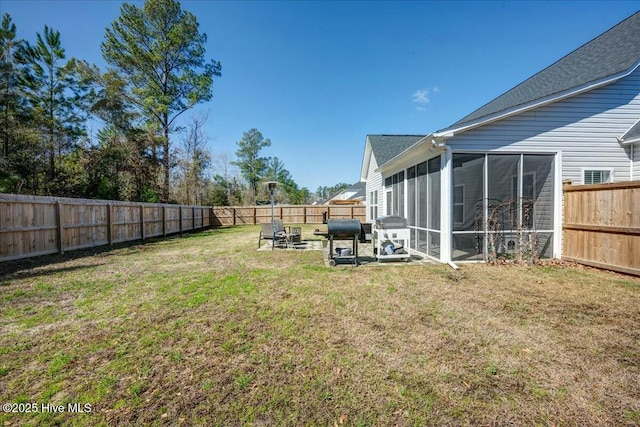 view of yard featuring a fenced backyard and a sunroom