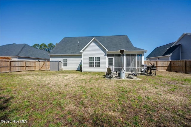 rear view of property featuring a sunroom, a lawn, and a fenced backyard