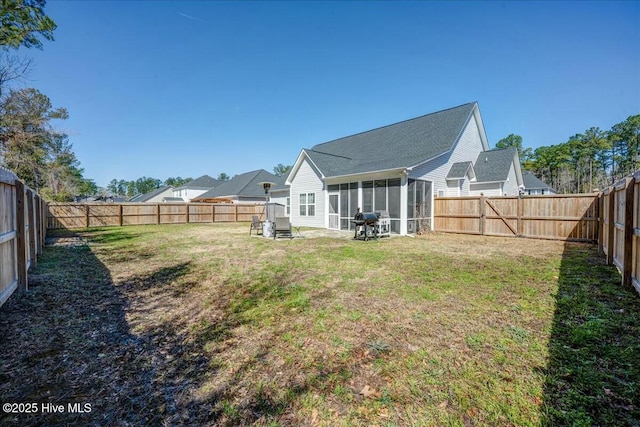 view of yard with a fenced backyard and a sunroom