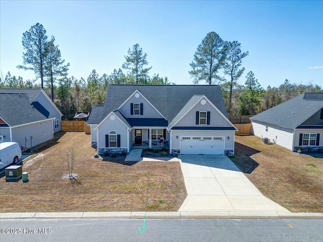 view of front facade with board and batten siding, fence, a porch, a garage, and driveway