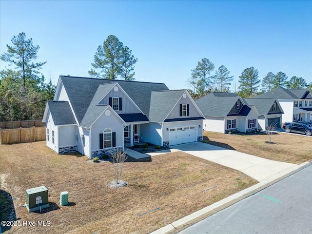 view of front of home with a front lawn, driveway, fence, board and batten siding, and a garage