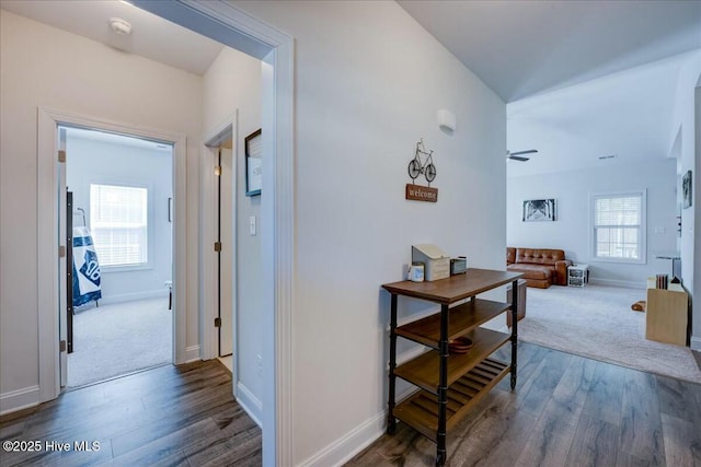 corridor with baseboards and dark wood-style flooring