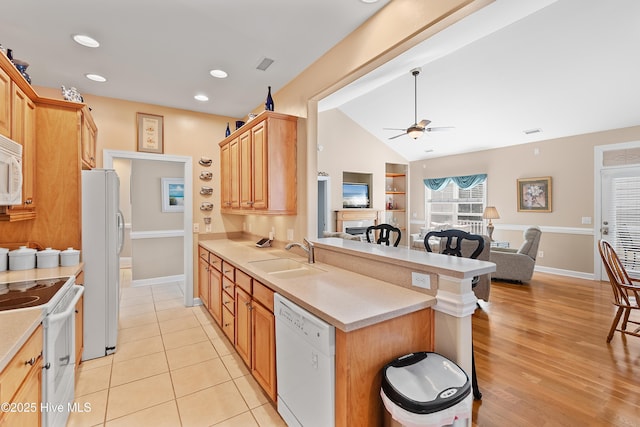 kitchen with visible vents, open floor plan, a peninsula, white appliances, and a sink