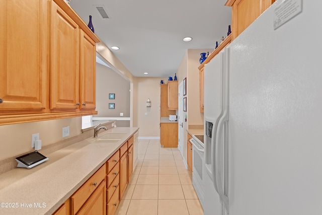 kitchen featuring visible vents, light countertops, light tile patterned flooring, white appliances, and a sink