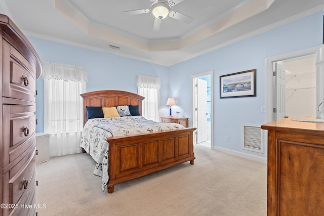 bedroom with a raised ceiling, multiple windows, visible vents, and light carpet