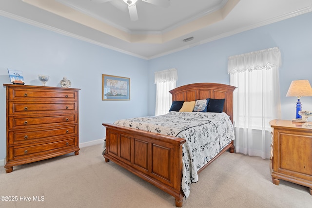 bedroom featuring visible vents, baseboards, crown molding, light carpet, and a raised ceiling