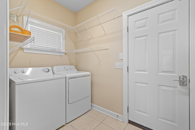 laundry room featuring laundry area, light tile patterned flooring, baseboards, and washing machine and clothes dryer