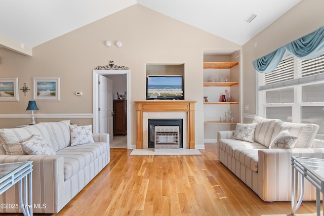 living area featuring built in features, visible vents, a fireplace with flush hearth, and light wood-style floors