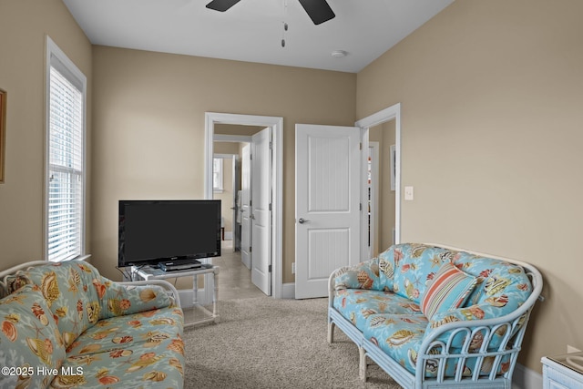 living area featuring a ceiling fan and light colored carpet