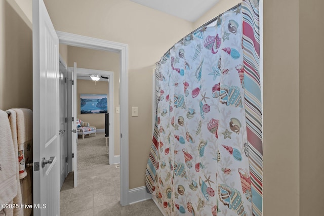 full bathroom with tile patterned floors, a shower with shower curtain, and baseboards