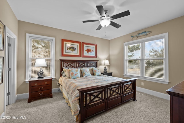 bedroom featuring light colored carpet, baseboards, and ceiling fan