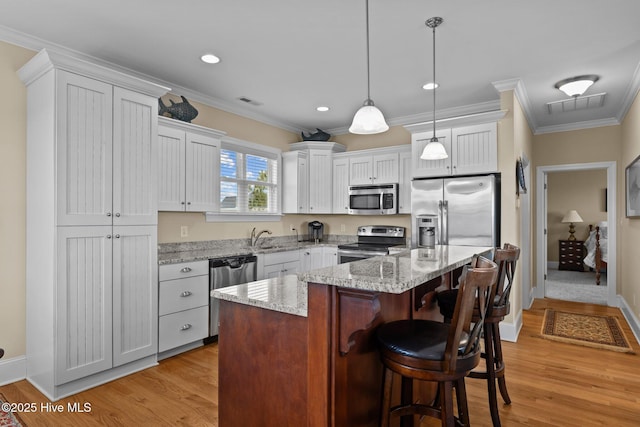 kitchen featuring light wood-style floors, visible vents, appliances with stainless steel finishes, and ornamental molding