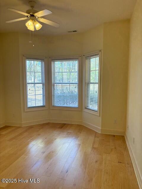 spare room featuring baseboards, visible vents, and light wood-type flooring