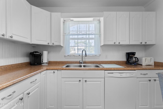 109 NE 17th St, Oak Island, NC 28465 - kitchen featuring white dishwasher, a sink, and white cabinetry