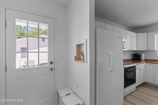 109 NE 17th St, Oak Island, NC 28465 - kitchen with white appliances, white cabinets, and light wood-style floors