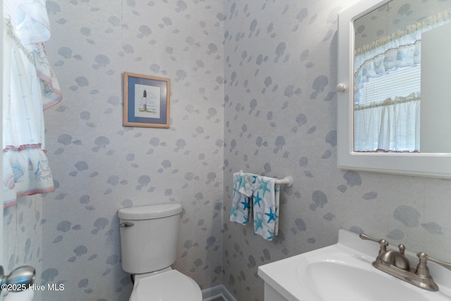 109 NE 17th St, Oak Island, NC 28465 - half bathroom featuring toilet, wallpapered walls, and vanity