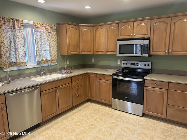 kitchen with a sink, recessed lighting, brown cabinets, and stainless steel appliances