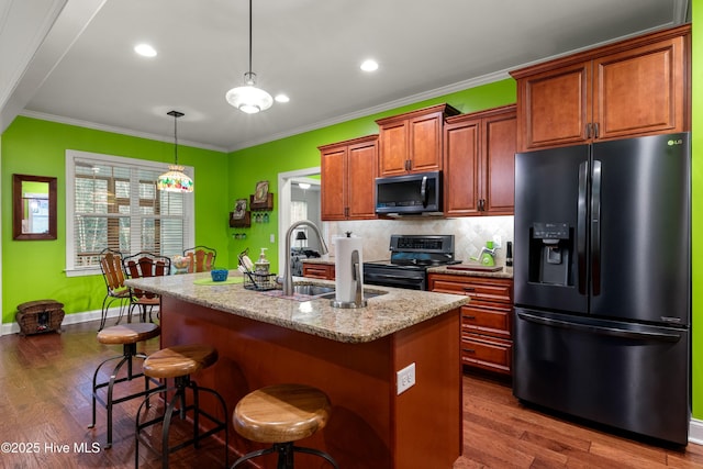 kitchen featuring a sink, range with electric stovetop, black fridge, and crown molding