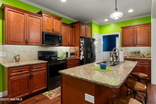 kitchen featuring black appliances, a sink, a kitchen breakfast bar, crown molding, and dark wood-style flooring