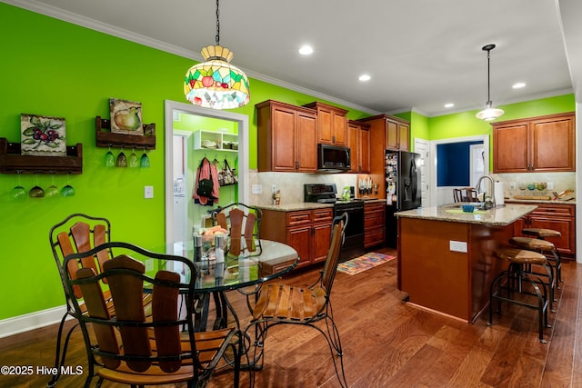 kitchen featuring a breakfast bar area, electric range, a sink, dark wood-type flooring, and black fridge