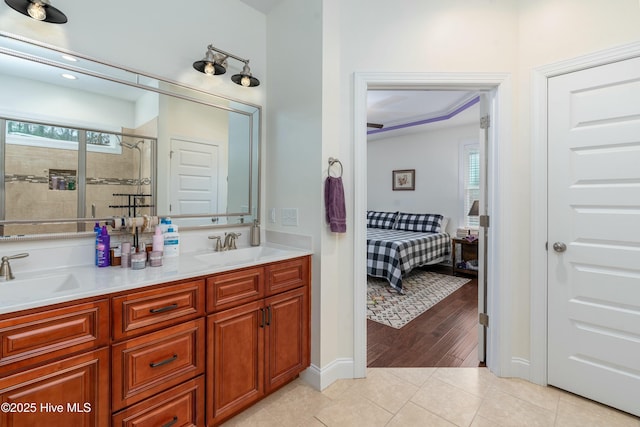 ensuite bathroom with ensuite bath, tile patterned floors, a shower stall, and a sink