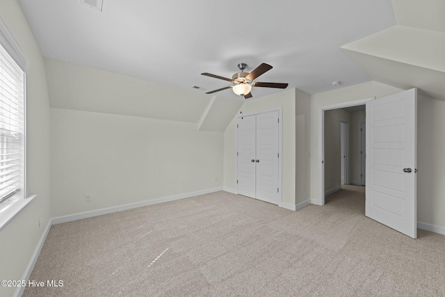 additional living space featuring baseboards, light colored carpet, a ceiling fan, and vaulted ceiling