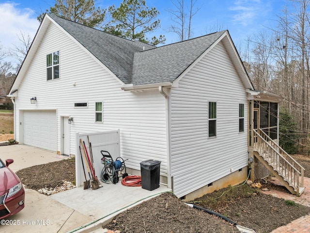 view of side of property with a shingled roof, an attached garage, a sunroom, and crawl space