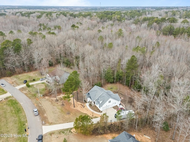 bird's eye view with a wooded view