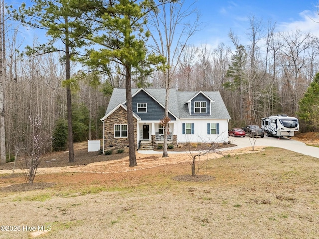 view of front of home featuring stone siding, a porch, a front lawn, and a shingled roof