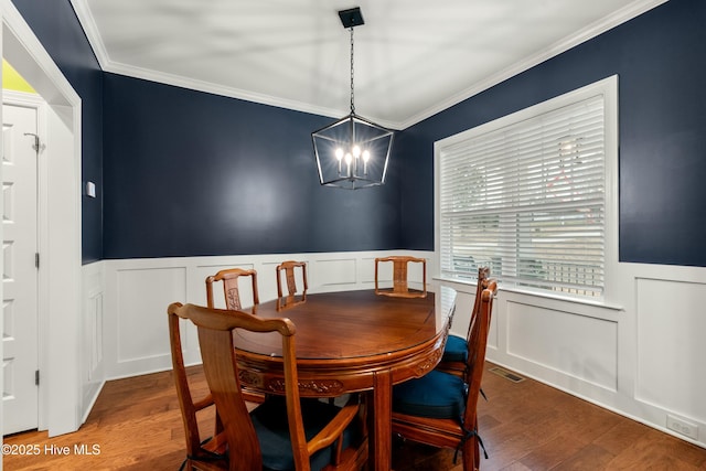 dining area with visible vents, a wainscoted wall, wood finished floors, and ornamental molding