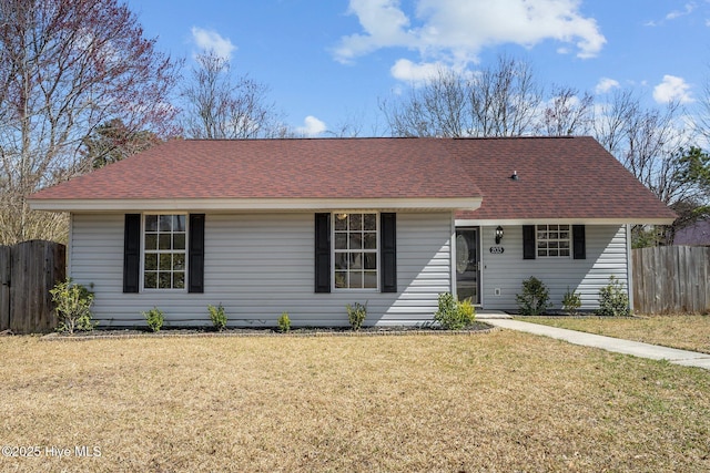 single story home featuring a shingled roof, a front lawn, and fence