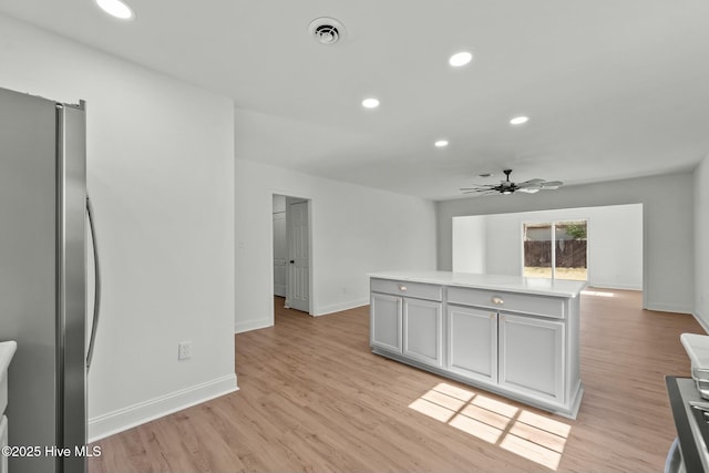 kitchen featuring visible vents, gray cabinetry, freestanding refrigerator, recessed lighting, and light wood finished floors