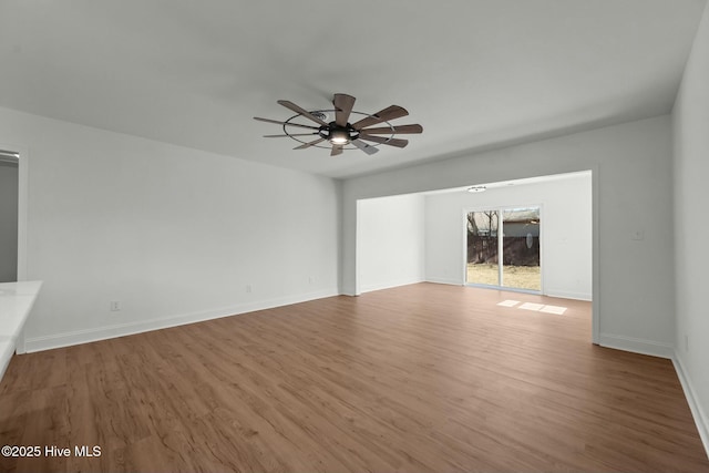 unfurnished living room with baseboards, wood finished floors, and a ceiling fan