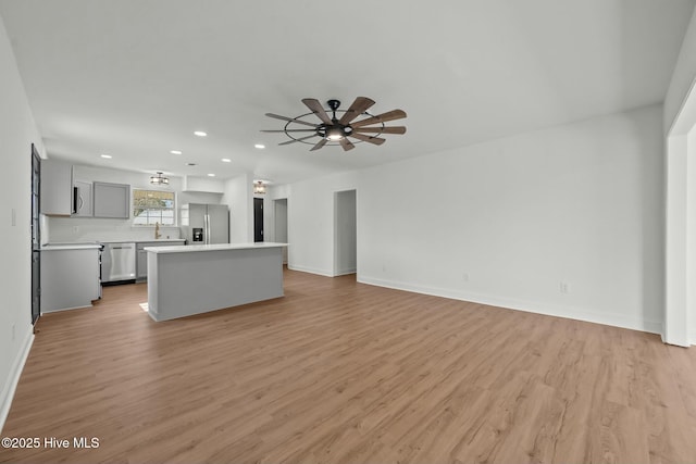 unfurnished living room with recessed lighting, baseboards, light wood-style floors, and a ceiling fan