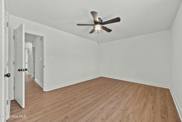 spare room with light wood finished floors, ceiling fan, and baseboards