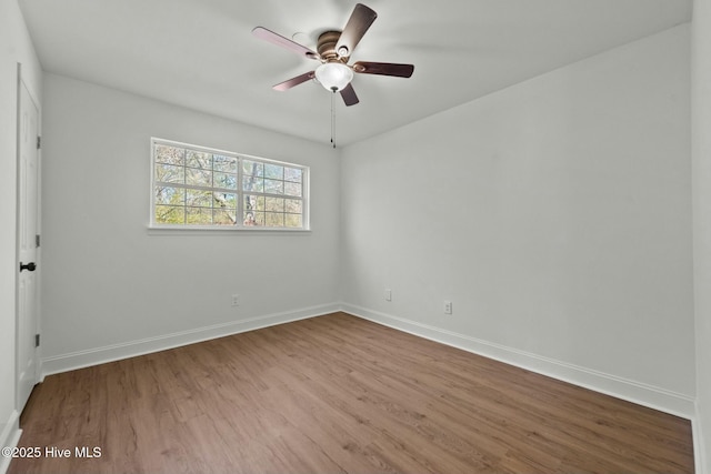 unfurnished room featuring baseboards, wood finished floors, and a ceiling fan