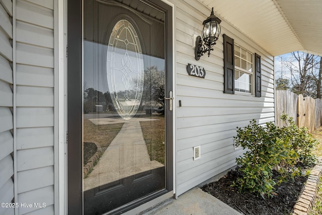 doorway to property featuring fence