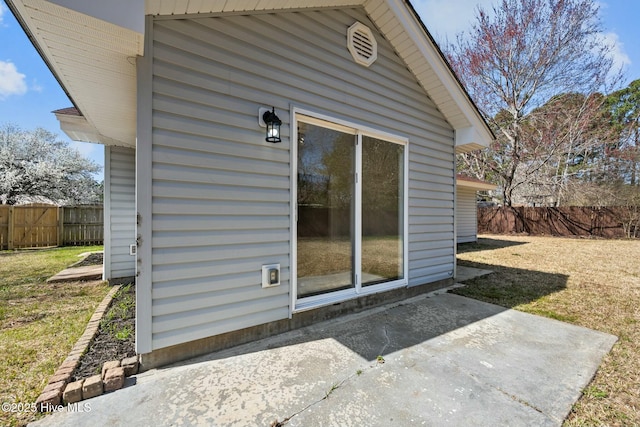 doorway to property with a yard, a patio, and fence