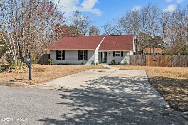 single story home featuring a gate, a shingled roof, concrete driveway, and fence