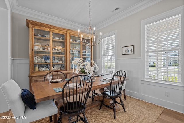 5151 Creswell Dr, Leland, NC 28451 - dining room with a decorative wall, crown molding, a chandelier, wainscoting, and healthy amount of natural light